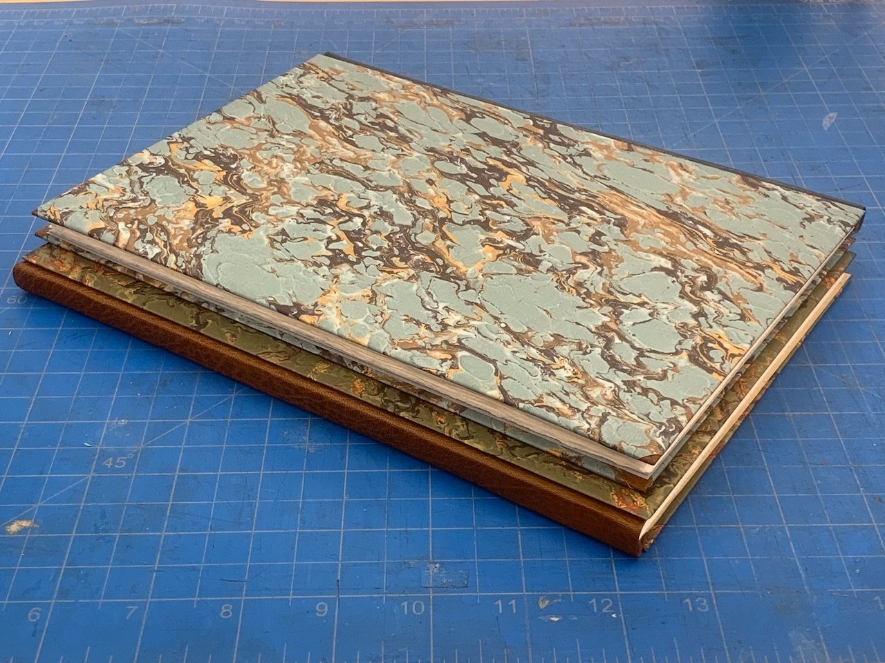 Marbled paper boards squared up on a cutting mat