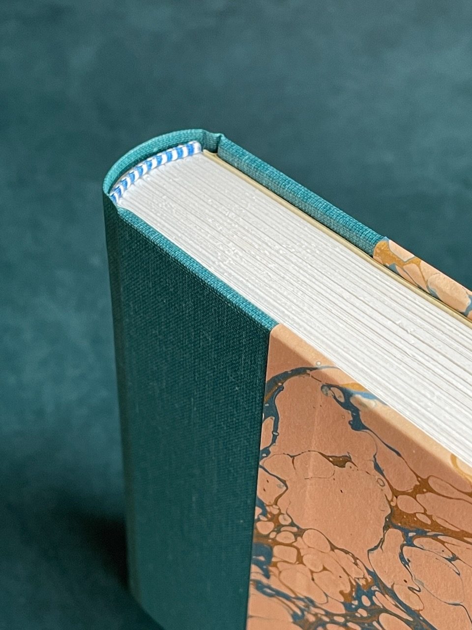 Close view of a finished binding's fore-edge and marbled turn-in