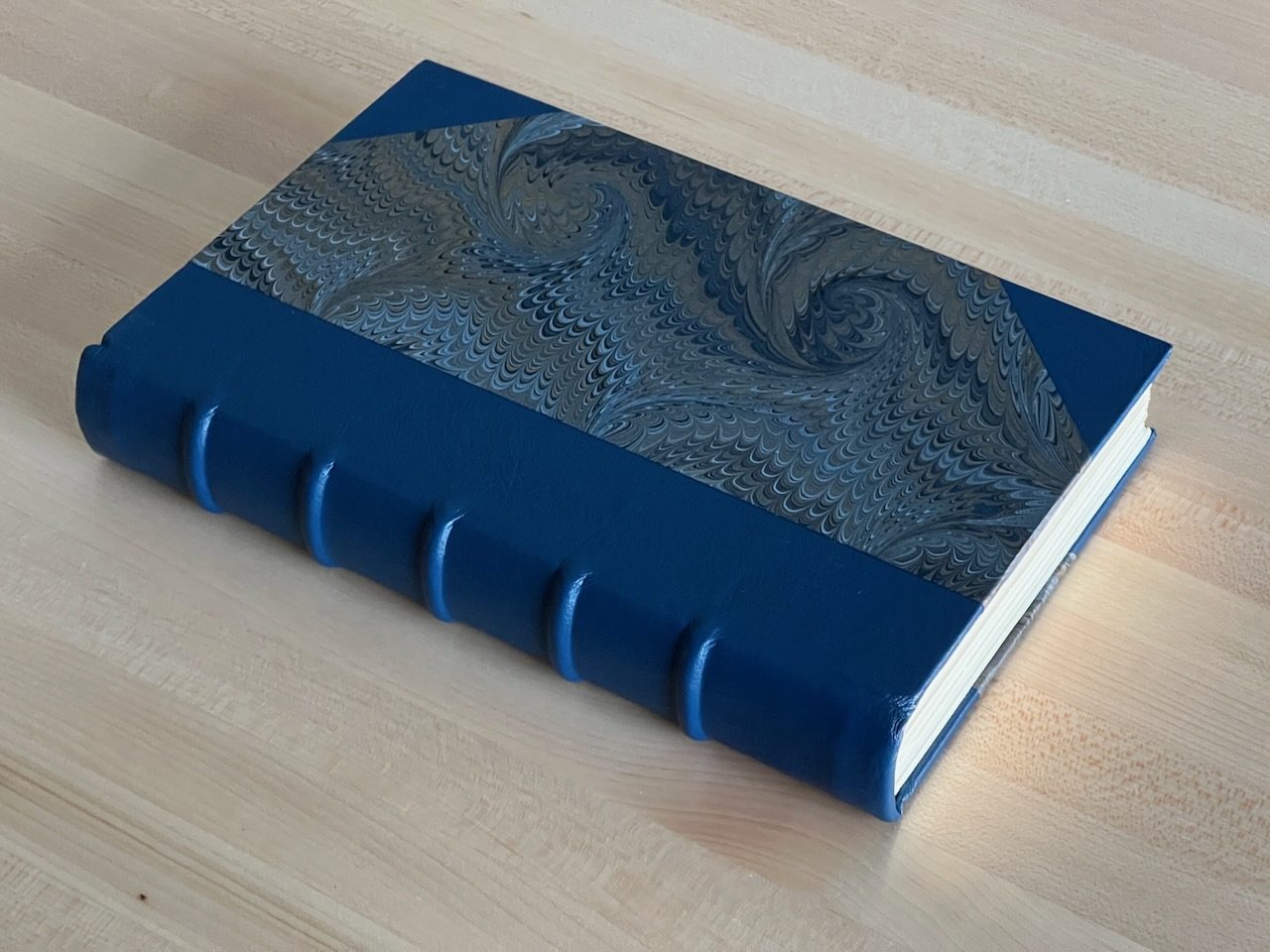 Blue leather binding with raised spine bands and marbled boards