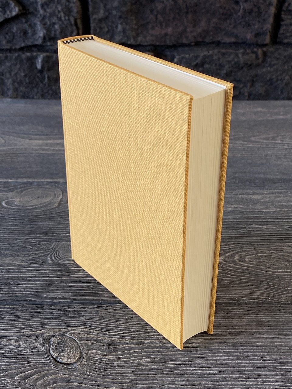 Cream paper-covered binding standing upright on a workbench